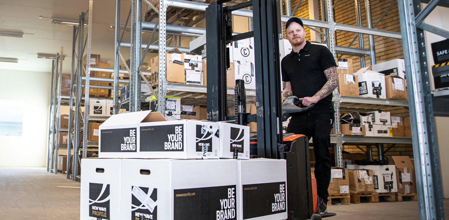 Lagermedarbetare kör gaffeltruck med stora beställningar