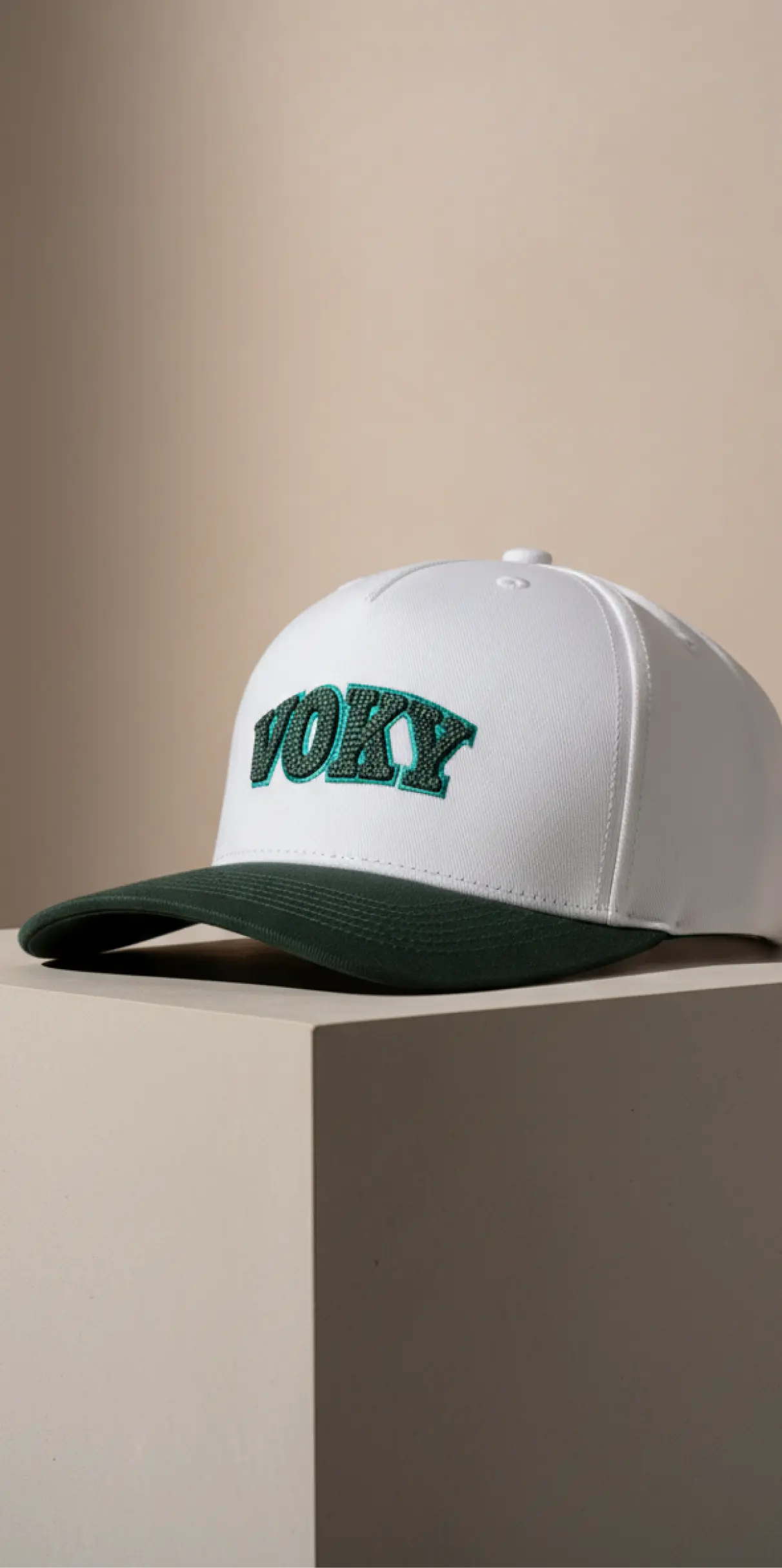 Vit keps med grön skärm och "voky" broderat i grönt.
