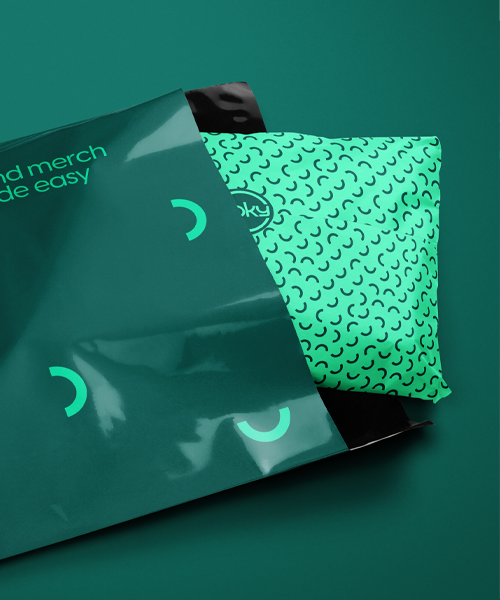 Mörkgrön Voky-märkt påse som innehåller en förpackning med mörkgrönt rosettmönster