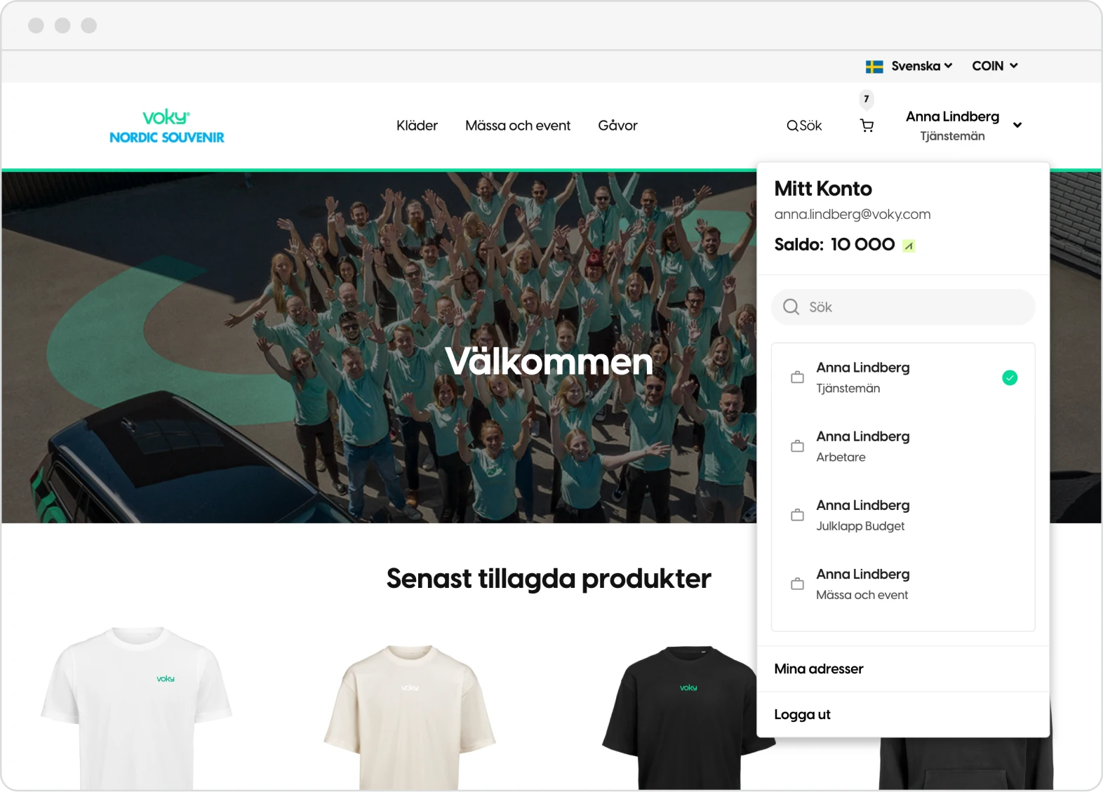 Startsidan i en webbshop med kundens egen logotyp, satt till svenska och valutan COIN. Kontopanelen är öppen och visar ett saldo på 10 000 och fyra konton på samma inloggning: Tjänstemän, Arbetare, Julklapp Budget samt Mässa och event.