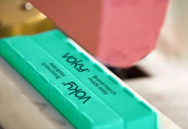 Voky-logotypen genomgår tampongtryck på en grön produkt